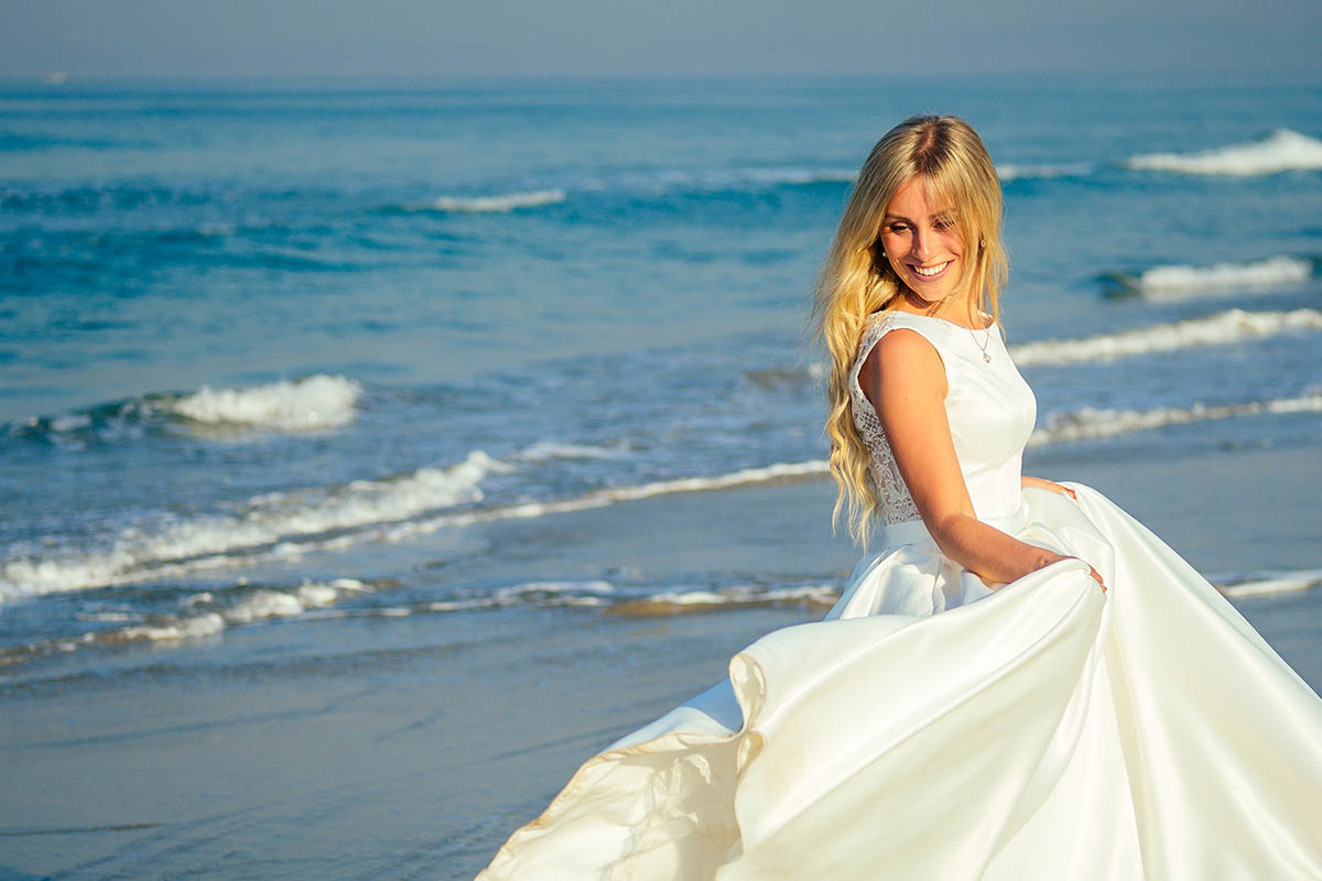 Eine glückliche Braut bei Hochzeitsfotografie nach eine Hochzeitszeremonie am Strand auf der Insel Ruegen