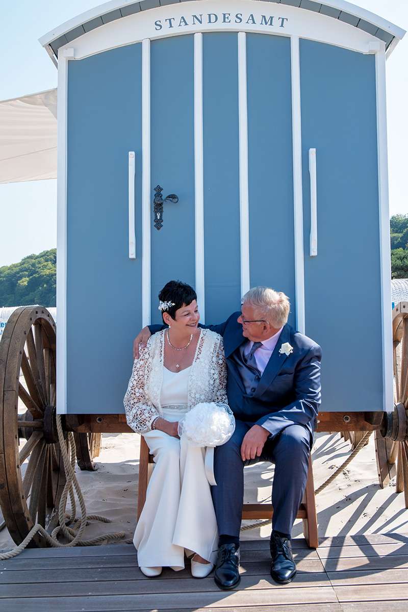 Hochzeit in Binz im Badekarren am Strand an der Ostsee mit authentischen Hochzeitsbilder von den Mazelle Photography Fotostudio®, dabei bietet der Badekarren zwar nur Platz für das Hochzeitspaar, der Standesbeamtin und dem Hochzeitsfotografen. Die Hochzeitsgästen können die Hochzeitszeremonie in den neben dem Badekarren aufgestellten Strandkörben verfolgen. Der Rügen Hochzeitsfotograf Mazelle arbeitet nur zu zweit, so werden nicht nur das Brautpaar fotografiert im Badekarren sondern auch die Hochzeitsgäste während der Trauung.