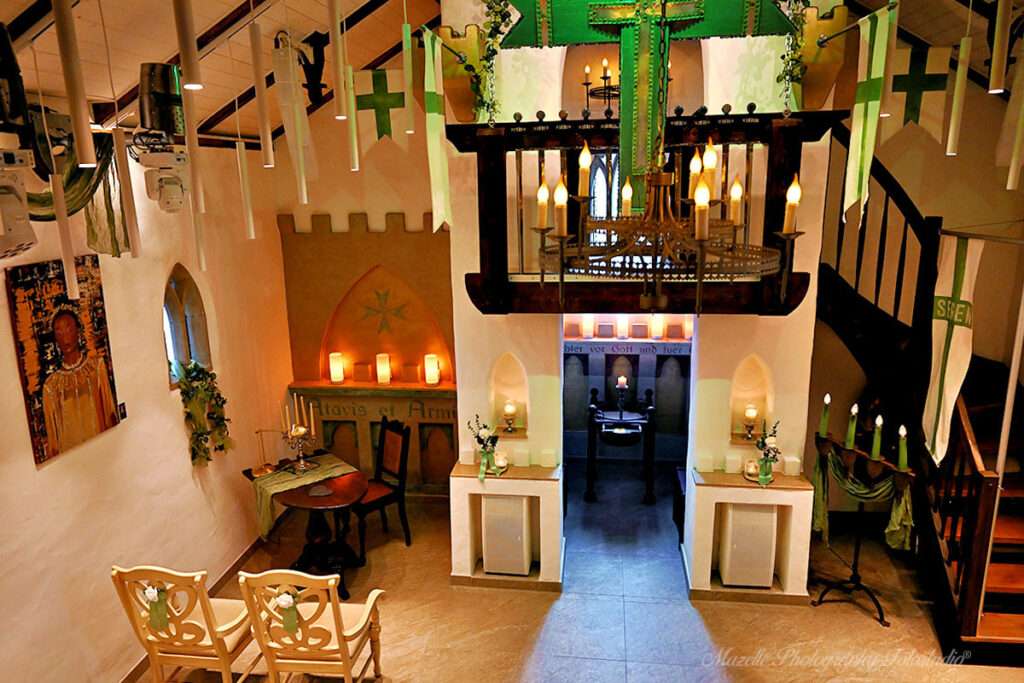 Ein Blick von oben in die historische Ordenskapelle Binz auf Rügen, wo seit 2025 standesamtliche Trauungen stattfinden. Die besondere Perspektive zeigt die festliche Atmosphäre dieser einzigartigen Location und macht die Zeremonie zu einem unvergesslichen Erlebnis. Der Hochzeitsfotograf des Mazelle Photography Fotostudio® aus Dranske auf Rügen begleitet die Trauungen fotografisch und hält die emotionalen Momente authentisch und stilvoll fest.